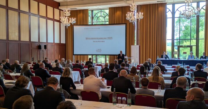 Tagung im Bad Homburger Kurhaus mit vielen Menschen, die einem Redner zuhören und auf eine Leinwand blicken.